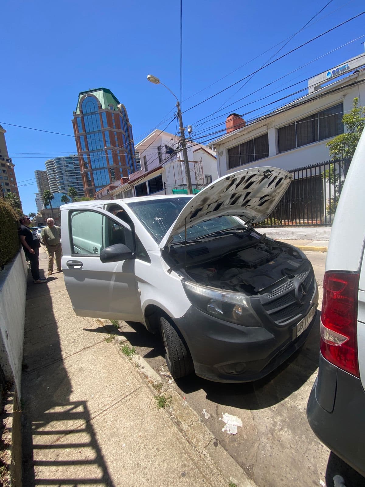 Revisión de una furgoneta blanca con el capó abierto